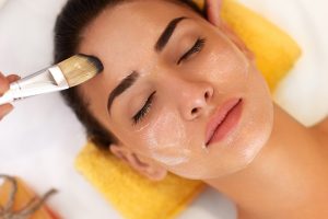 Face Treatment. Woman in Beauty Salon Gets Marine Mask